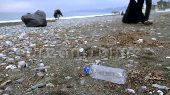 志愿者在秋天清理海滩上的垃圾环境问题视频的预览图