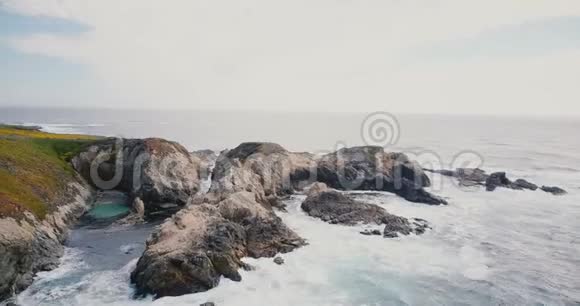 美丽的电影空中拍摄田园诗般的海浪撞击大岩石在夏季大苏尔海岸加州视频的预览图
