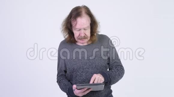 戴着胡子的老人用数码平板电脑听到坏消息视频的预览图