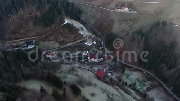 空中拍摄的山脉覆盖着树木有一个小村庄4k视频的预览图