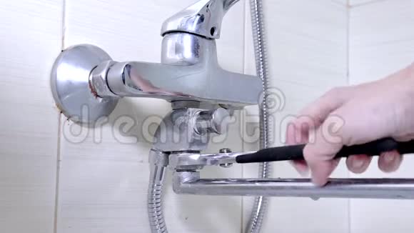 浴缸水龙头重新打开拧开漏水的淋浴水龙头上的螺母管道修理和DIY概念视频的预览图