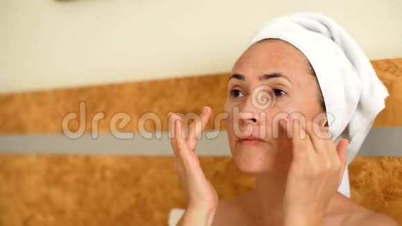 女人脸上涂一层润肤霜女人做面部按摩视频的预览图