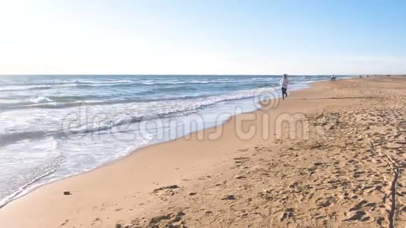 女人正在沙滩上慢跑海浪很美视频的预览图