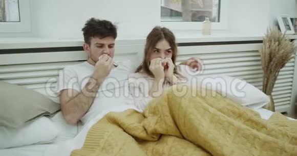 对于一对感觉不好的年轻夫妇来说流感时间到了他们躺在毯子下面流着鼻涕视频的预览图