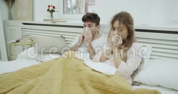 年轻夫妇得了流感他们躺在毯子下面的床上感觉太糟糕了视频的预览图