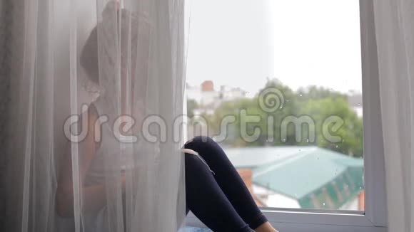 女孩坐着躲在窗帘后面视频的预览图
