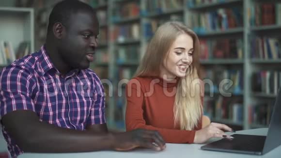 带笔记本电脑的非裔美国人和白人金发视频的预览图