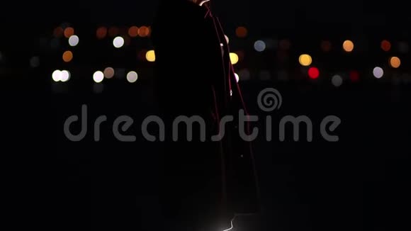 体贴悲伤的女人站在夜晚的城市灯光下视频的预览图