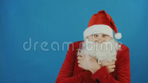 圣诞节和新年像圣诞老人一样的人在蓝色的背景下颤抖或结冰视频的预览图