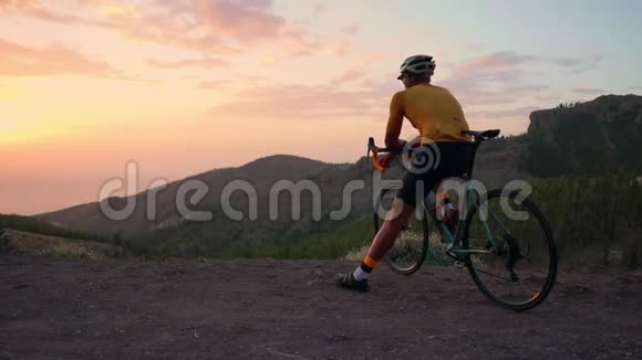 骑自行车的游客从山顶欣赏日落视频的预览图