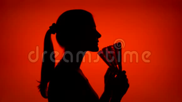 女人用手扇的剪影红色背景下女性脸部轮廓的黑色轮廓阴影视频的预览图