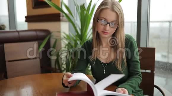 女人坐在咖啡馆里翻书视频的预览图