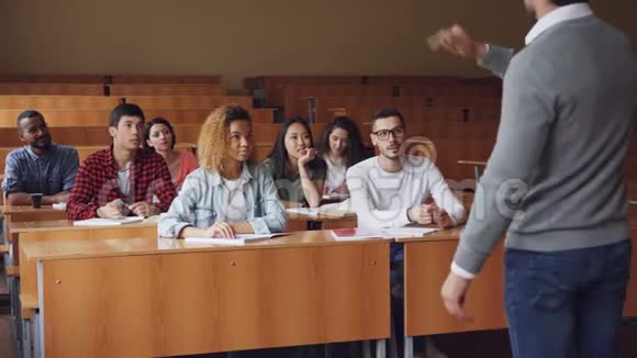 多民族学生举手回答老师问题戴眼镜的人给出正确的答案视频的预览图