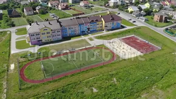鸟瞰儿童在一个小足球场上踢足球学校附近的现代足球场视频的预览图