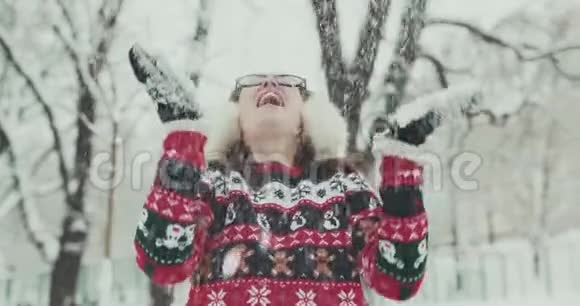 年轻女性在户外享受冬日白雪皑皑的冬季雪花视频的预览图