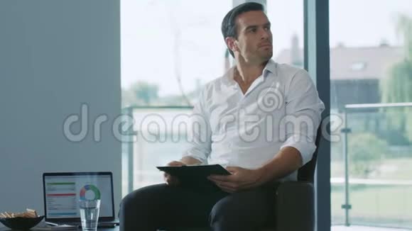 商人坐着笔记本专业处理图表文档视频的预览图