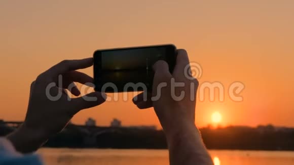 在城市码头用智能手机拍照日落视频的预览图