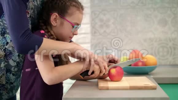妈妈帮女儿在砧板上切苹果妈妈亲手给孩子做饭视频的预览图