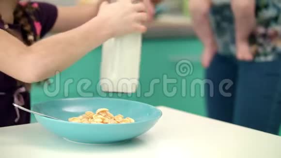 女孩把牛奶倒进玻璃碗里的玉米片健康生活方式视频的预览图