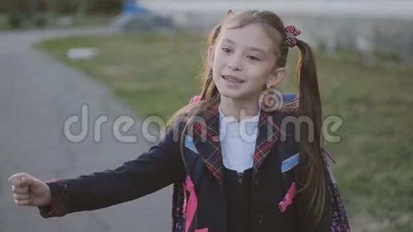 小女生唱着欢快的歌舞穿校服和背包的女孩慢动作视频的预览图