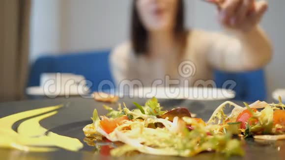 那个女孩在沙拉向别人伸出手来有选择地专注于沙拉视频的预览图