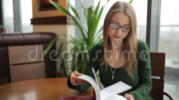 女人坐在咖啡馆里翻书视频的预览图