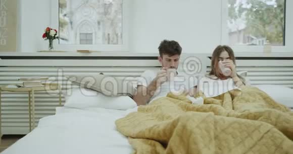 一对夫妇得了流感他们感觉很不好躺在床上喝了些热饮料流了很多鼻涕视频的预览图
