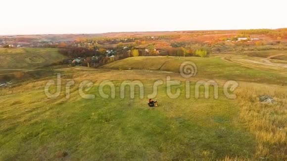 日落时分女孩和美国斯塔福德郡的猎犬坐在乡下视频的预览图