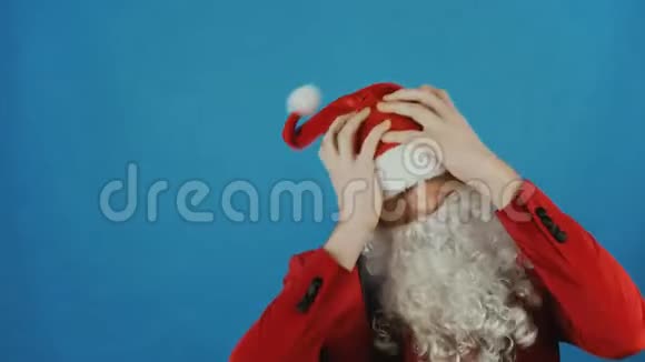 圣诞节和新年像圣诞老人一样的人失望地摇着头在蓝色的背景下视频的预览图