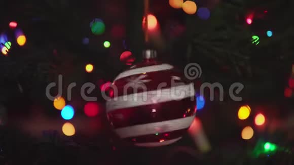 带有雪花和条纹的红色圣诞球在树枝上旋转视频的预览图