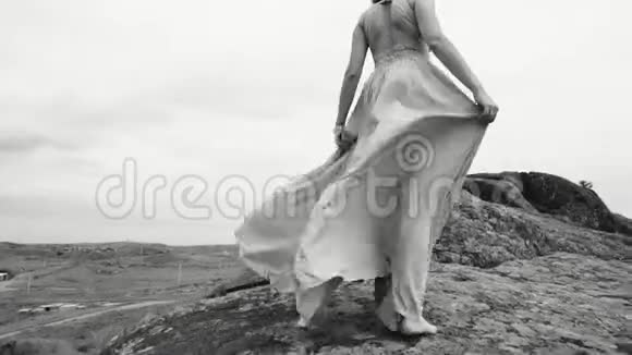 女孩光着脚走着石头拿着裙子视频的预览图