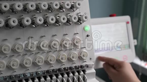 操作人员设置数控机床一名工人正在用平板电脑编程一台数控缝纫机视频的预览图