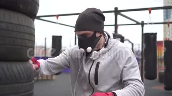 男子运动员在训练面具和拳击类型的拳击在街头训练场视频的预览图