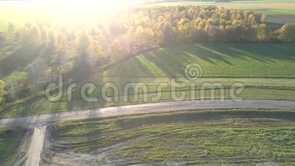 空中景色空旷的田野在阳光照射下穿过马路视频的预览图