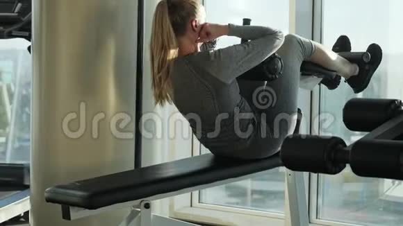 运动型漂亮的中年妇女做腹肌锻炼视频的预览图