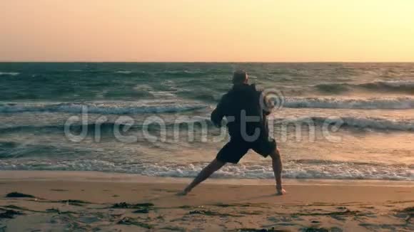 太阳升起时在海滨做伸展运动和练习瑜伽视频的预览图