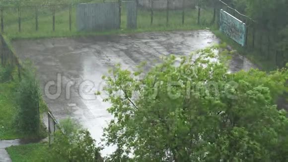 城市里的夏季大雨绿色庭院和操场的顶部景观4K视频视频的预览图