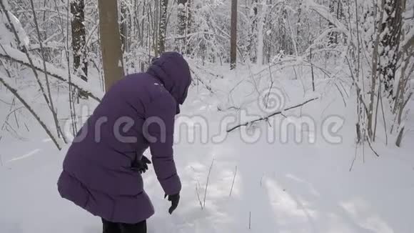 老妇人玩得很开心从地上捡起雪扔到空中视频的预览图