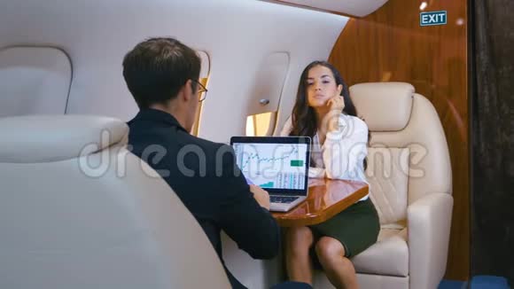 成功的商人驾驶私人飞机在笔记本电脑上工作使用智能手机商人和女商人视频的预览图