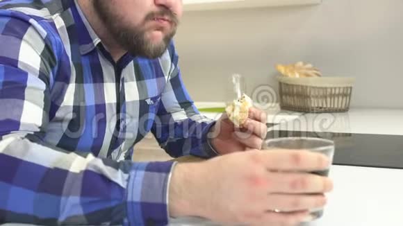 穿格子衬衫留着胡子的胖子吃快餐芝士汉堡用有害的柠檬水冲洗额外的卡路里视频的预览图