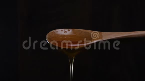 手指蘸蜂蜜从木制勺子视频的预览图