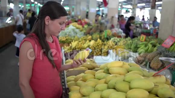 女孩在市场上选择新鲜水果芒果关门了视频的预览图