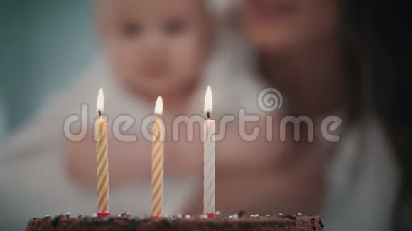 妈妈在婴儿生日蛋糕上吹了三支蜡烛宝宝生日派对理念视频的预览图