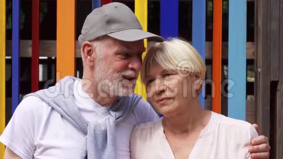 微笑的老夫妇站在彩色墙背景上免费旅游家庭享受假期视频的预览图