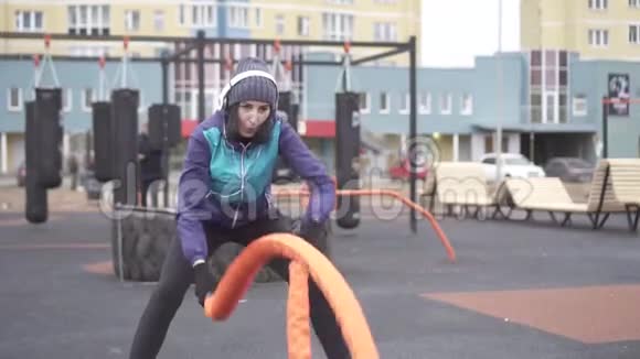 女子运动员在街头操场上用绳子做交叉比赛慢莫视频的预览图