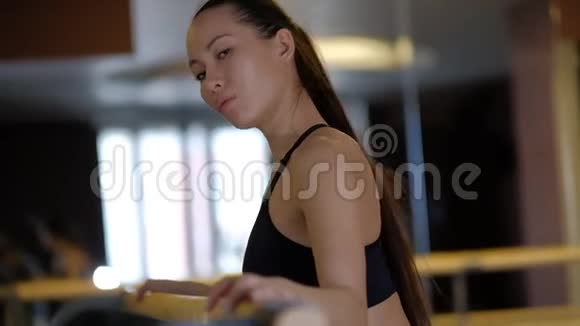 美丽的女孩用镜子在芭蕾舞扶手上展示手臂的伸展视频的预览图