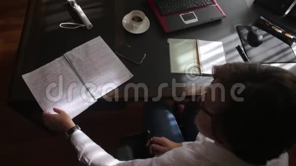 女人在桌旁翻阅笔记本视频的预览图