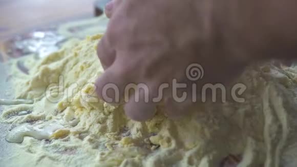 男手用面粉和鸡蛋捏面团厨师在厨房桌子上做面团慢动作视频的预览图