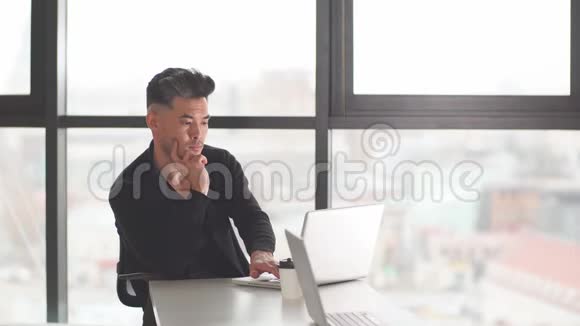 中国商人坐在办公桌前用电脑的画像视频的预览图