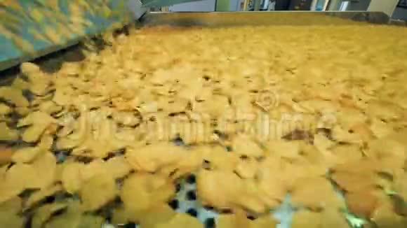 许多黄色薯片在工厂生产线上移动自动化工厂设备正在工作视频的预览图